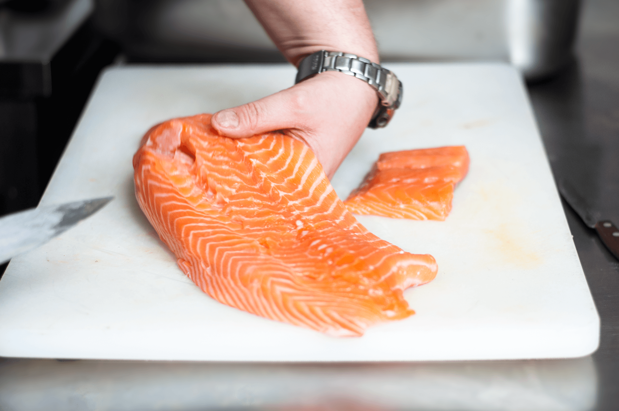 Kucharz starannie oporządza łososia, który po przygotowaniu trafi na restauracyjny strół